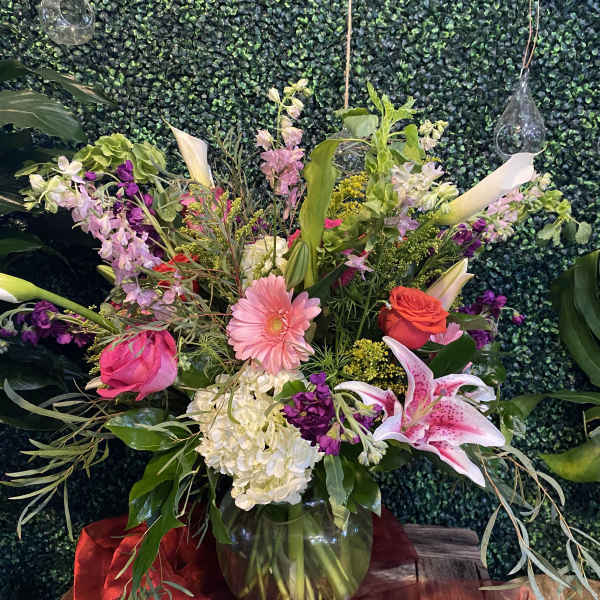 Mixed bouquet in a glass vase with pink, red, white, and purple flowers