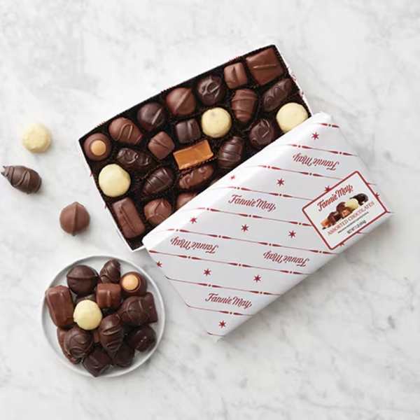 Box of assorted chocolates with a few pieces scattered beside it