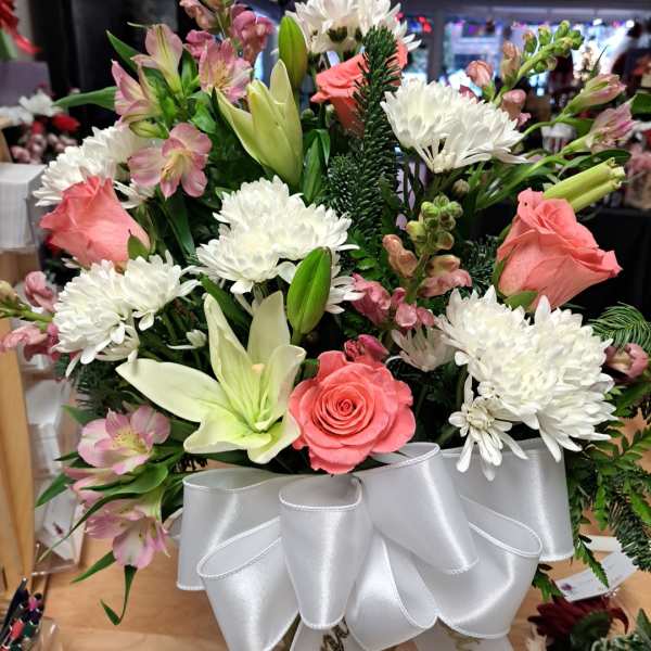 Bouquet of pink roses, white lilies, and white chrysanthemums with a white ribbon