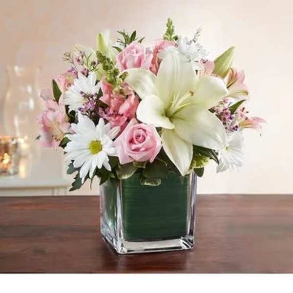 Pink and white flower arrangement in a square glass vase