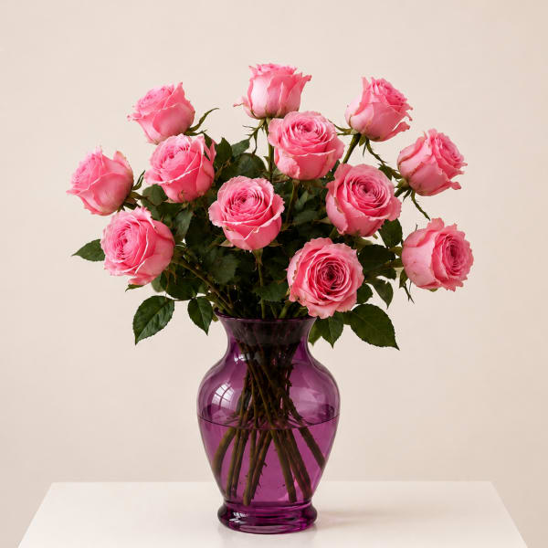 Pink roses arranged in a purple glass vase
