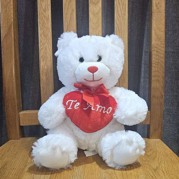 White teddy bear holding a red heart with "Te Amo" text