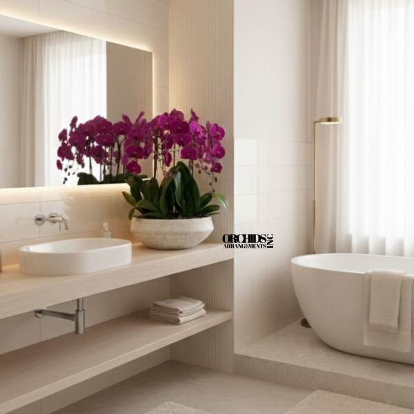 Purple orchid arrangement in a stone bowl on a bathroom counter