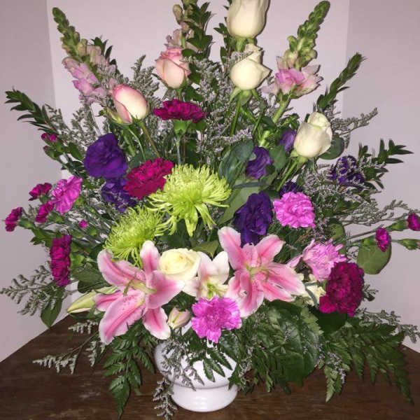 Large mixed bouquet in a white vase with pink lilies and roses