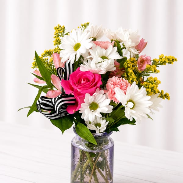Pink rose and white daisy bouquet in a glass jar vase