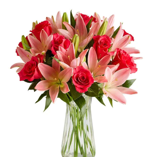 Pink lilies and red roses arranged in a clear glass vase