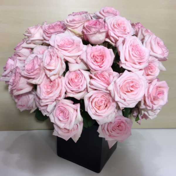 Bouquet of pale pink roses in a black box vase