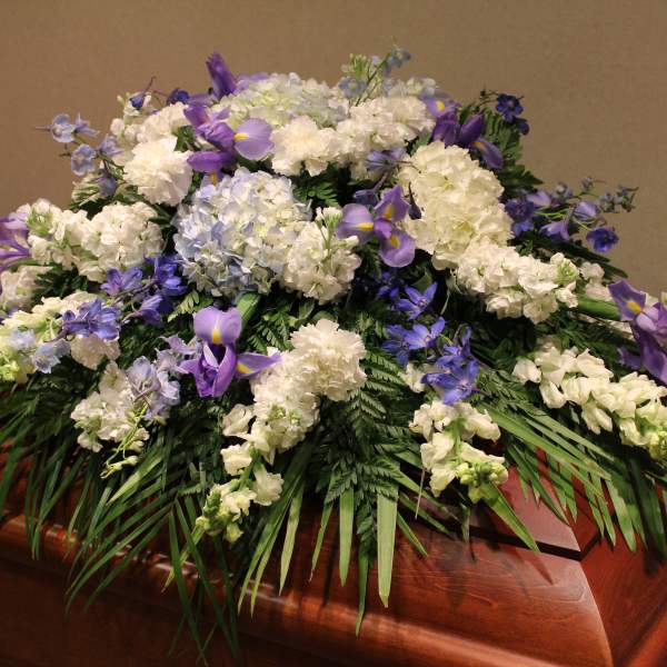 White and purple funeral spray on a casket