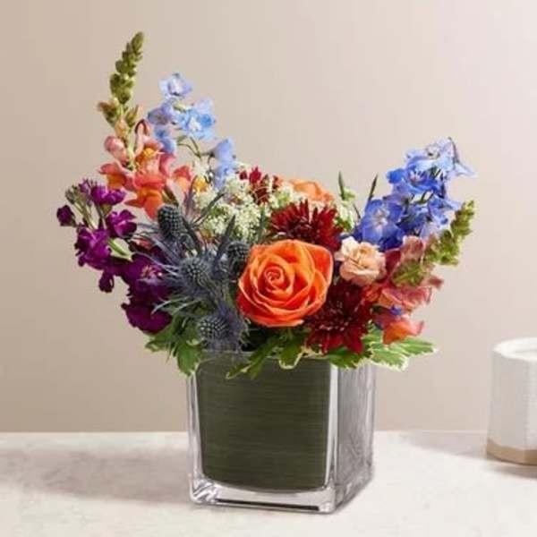 Colorful mixed bouquet in a square glass vase