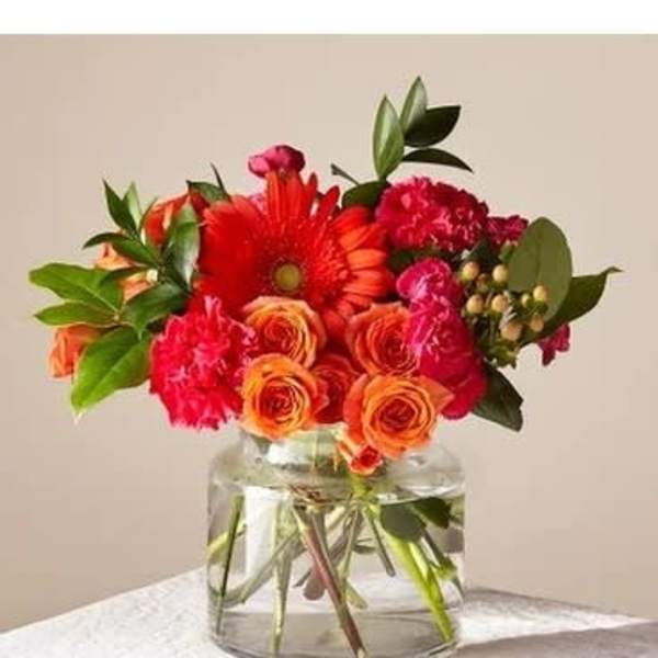 Bouquet of red and orange flowers in a clear glass vase