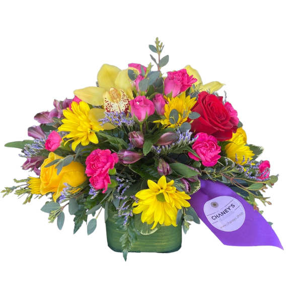 Mixed bouquet of roses, daisies, and orchids in a green vase