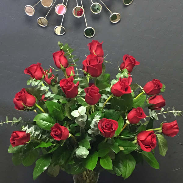 Red roses arranged in a clear glass vase