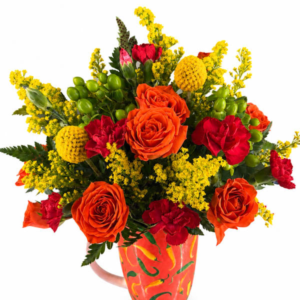 Bouquet of orange and red flowers in a painted mug vase
