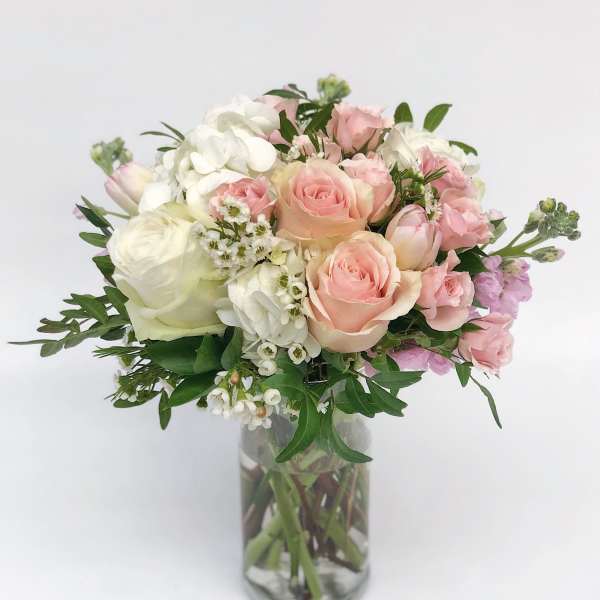 Pink and white rose bouquet in a clear glass vase