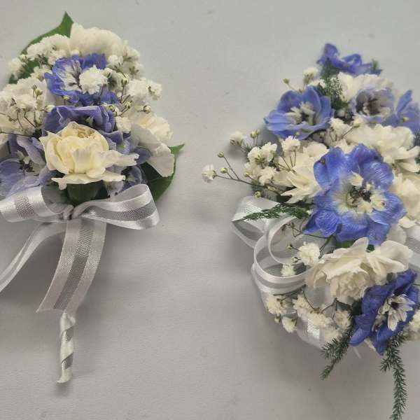 Two small wedding bouquets with blue and white flowers tied with white ribbon