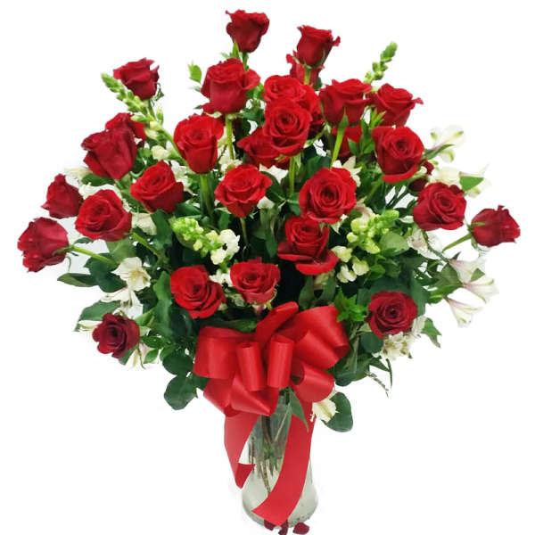 Bouquet of red roses with white flowers in a glass vase and red ribbon