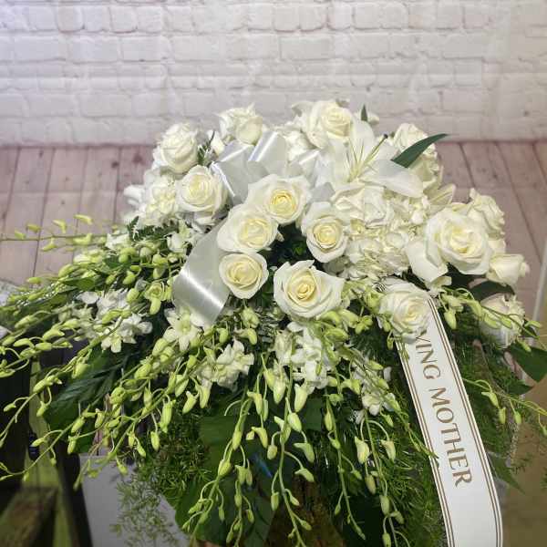 White rose and lily arrangement with a satin ribbon and mother tribute tag