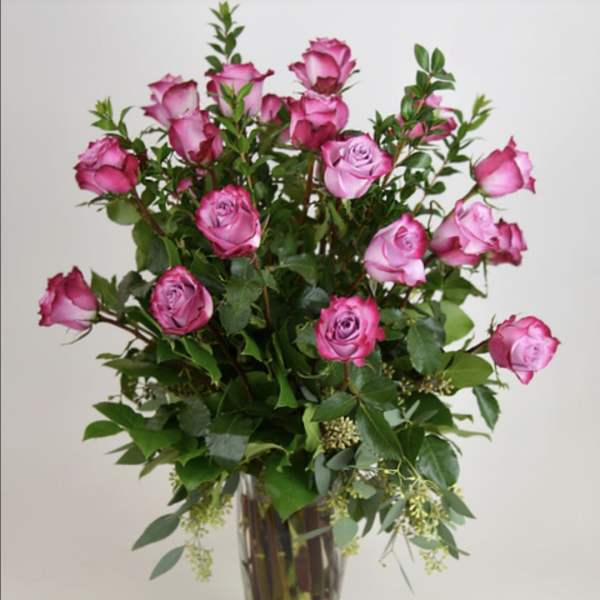 Tall bouquet of pink roses in a clear glass vase