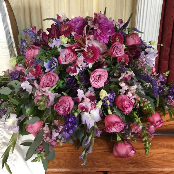 Large bouquet of pink and purple flowers on a wooden table