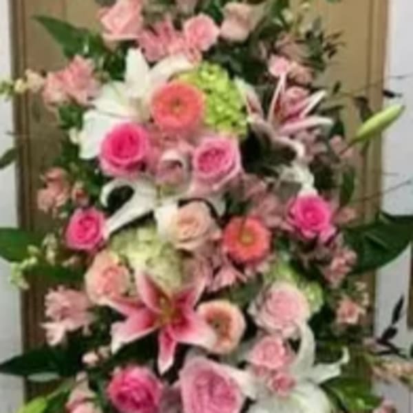 Tall pink and white floral arrangement with lilies and roses
