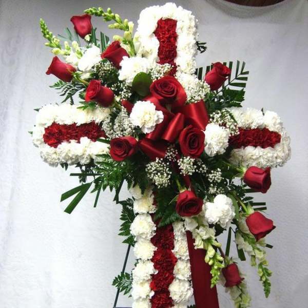 Red and white floral standing cross on an easel