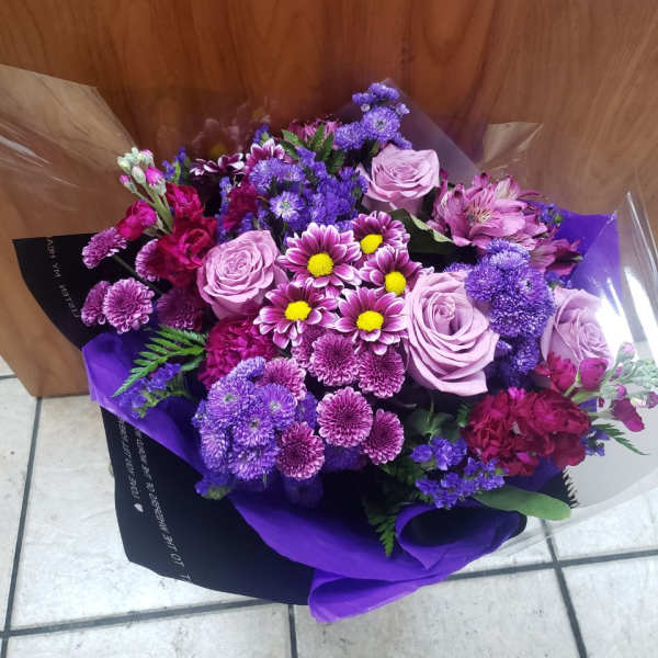 Bouquet of purple and pink flowers wrapped in purple paper