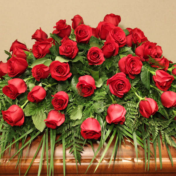 Casket spray of red roses with greenery