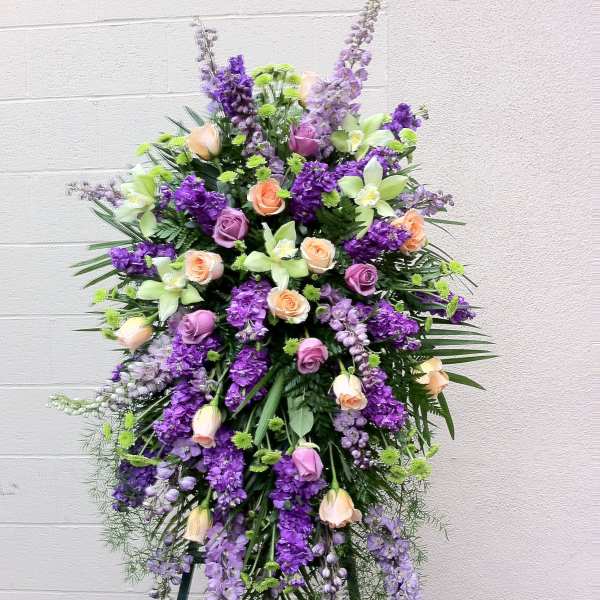 Tall standing floral spray with purple and peach roses