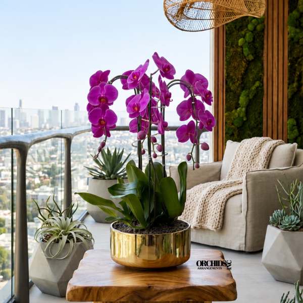 Purple orchids in a gold pot on a wooden table