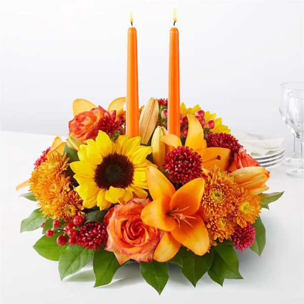 Orange floral centerpiece with two orange candles