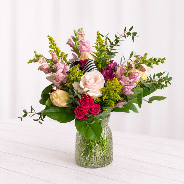 Mixed pink and white flowers in a clear glass vase