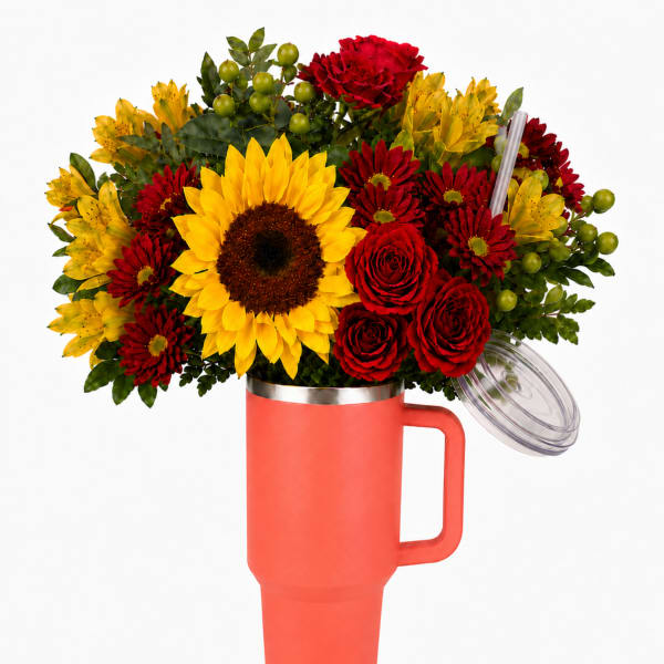 Bouquet of red and yellow flowers in a coral tumbler vase with lid and straw