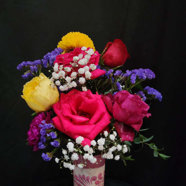 Mixed roses with baby's breath in a pink vase