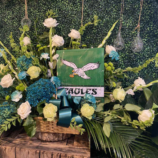 Large floral arrangement with white roses and blue hydrangeas in a basket