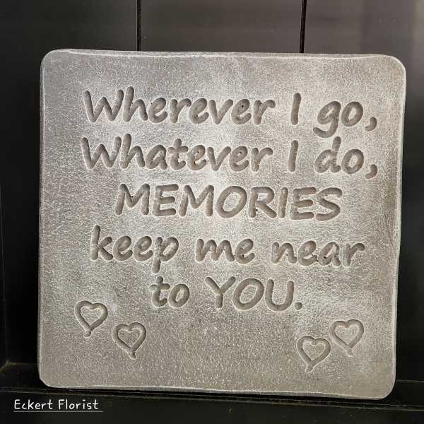 Gray memorial plaque with engraved quote and small heart balloons