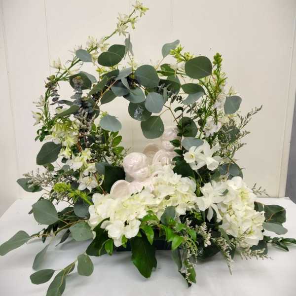 White floral wreath with eucalyptus and angel figurines