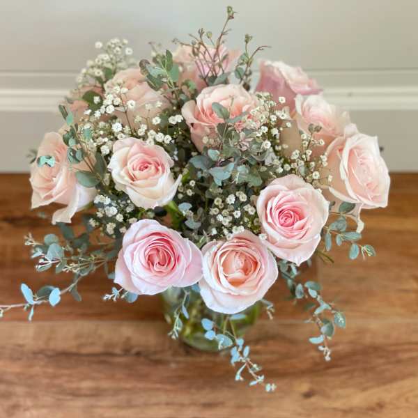 Pink roses and baby's breath in a glass vase