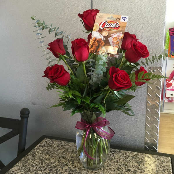 Bouquet of red roses in a glass vase with a gift card