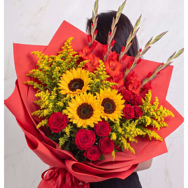 Bouquet of red roses and yellow sunflowers wrapped in red paper