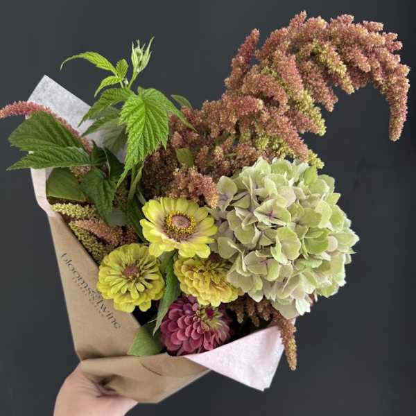 Handheld bouquet with yellow and pink flowers and pale green hydrangea