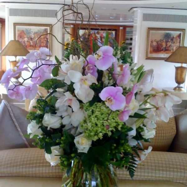 Large bouquet of pink and white orchids in a clear glass vase