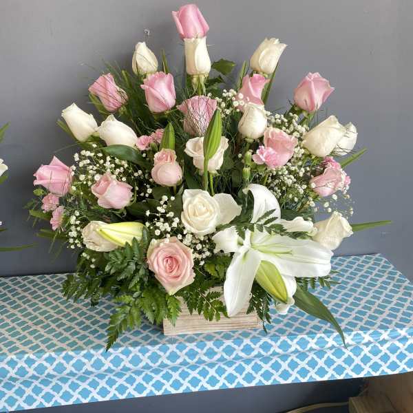 Pink and white roses with lilies in a wooden box arrangement