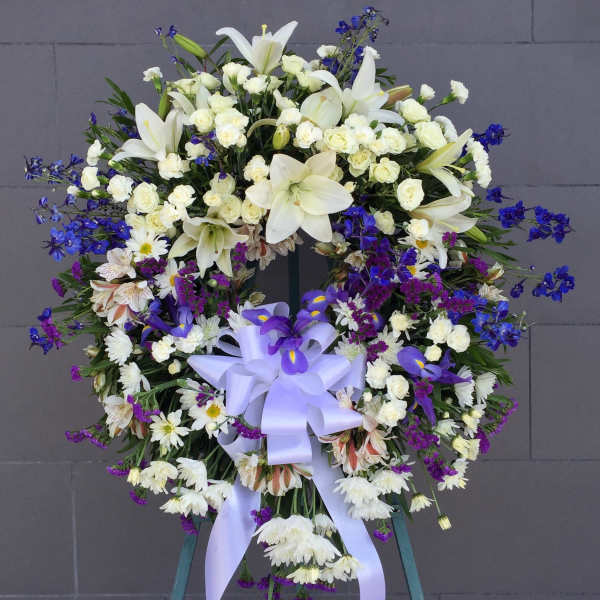 Large white and purple funeral wreath with a lavender ribbon