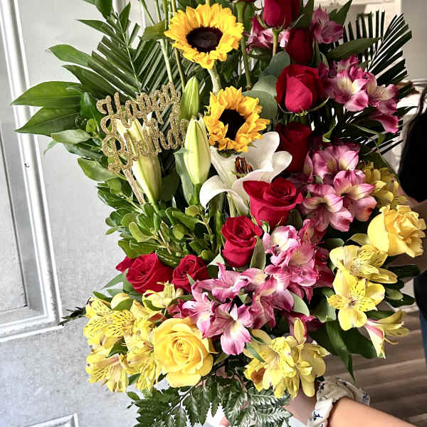 Tall bouquet of red roses, white lilies, and yellow sunflowers