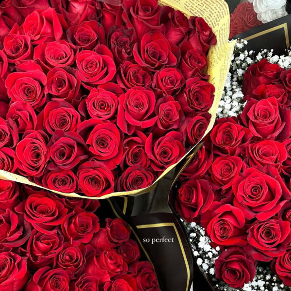 Bouquets of red roses wrapped in black paper with gold trim