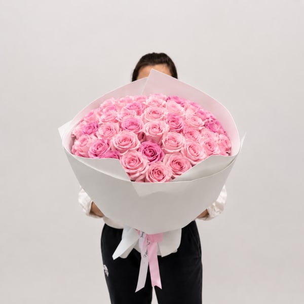 Large bouquet of pink roses wrapped in white paper