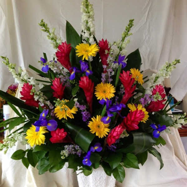 Colorful tropical flower arrangement in a white basket