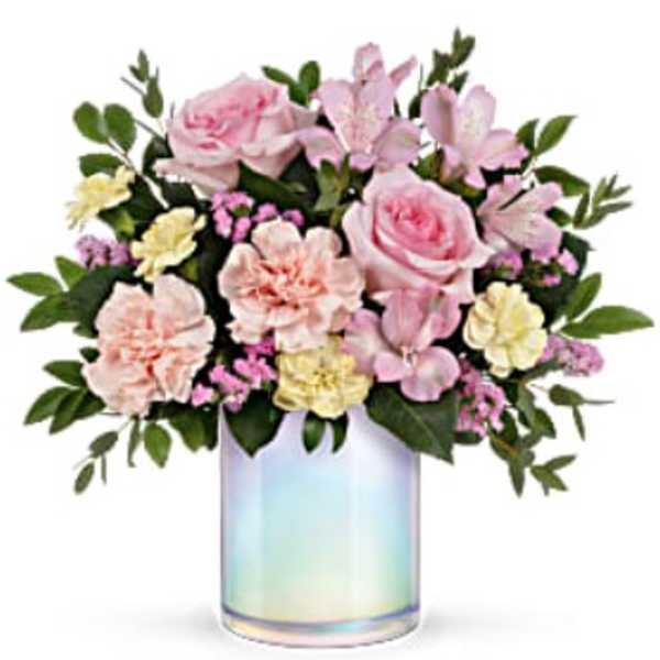 Pink and cream flowers arranged in an iridescent glass vase