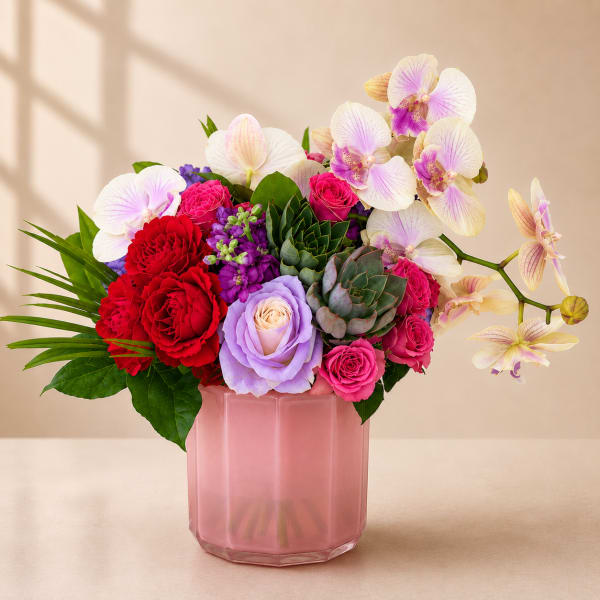 Pink vase arrangement with orchids, roses, carnations, and succulents