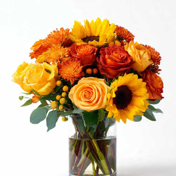Bouquet of yellow and orange flowers in a clear glass vase